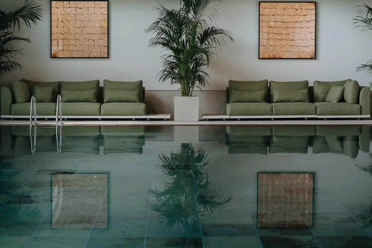 The pool at Special Sports in Amstelveen, with sofas and palms along the side
